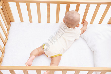 可爱宝宝在婴儿床里玩耍背景图片