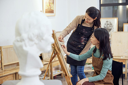 手绘中国女孩画室里老师指导学生画画背景