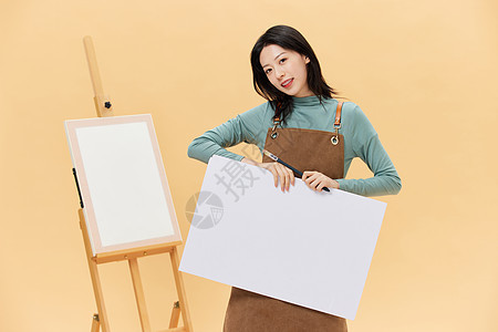 站在画板旁边的女性手拿白板图片