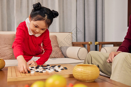 春节期间小女孩和爷爷下围棋高清图片