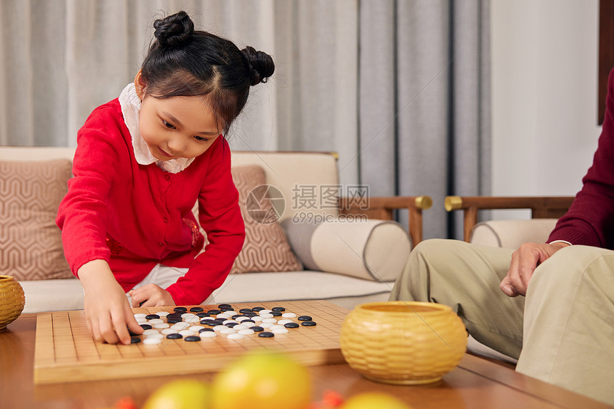 春节期间小女孩和爷爷下围棋图片