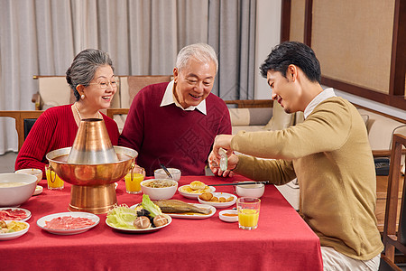 年夜饭男青年给父母倒酒高清图片