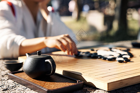 中式扇子古风美女户外喝茶下棋特写背景