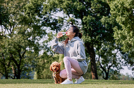 跑步喝水蹲着喝水的运动少女背景