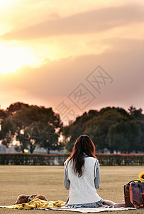 户外健身美女坐在草地上看书的清新美女背影背景