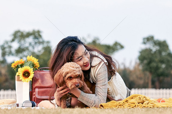 美女与小狗在草地上互动图片