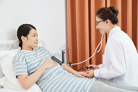 妇科女性妇产科医生为孕妇测量血压背景
