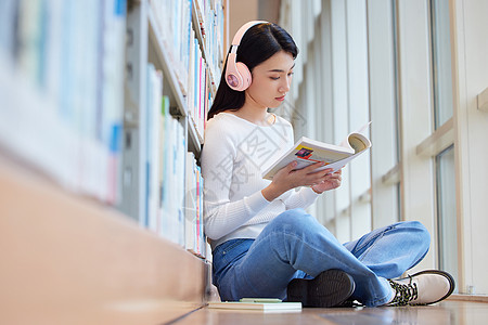 女学生在图书馆看书听音乐高清图片