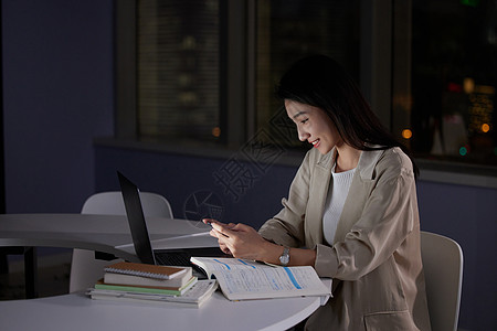 女大学生深夜在自习室玩手机高清图片