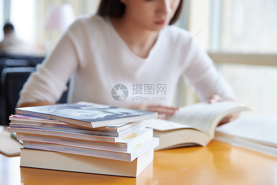 青年女性在自习室学习看书特写图片