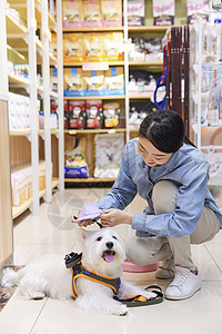 美女主人带宠物狗狗逛宠物店选购商品图片