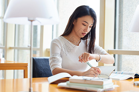 学生时间青年女性图书馆自习看手表时间背景