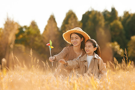 母女二人秋天在稻田里郊游图片