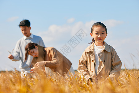 在田野里郊游的一家三口形象高清图片