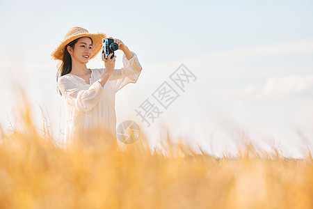 风景摄影师拍摄穿着连衣裙的女性站在稻田里拍照背景