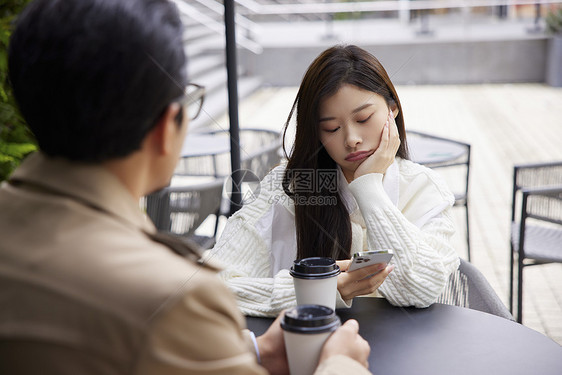 青年男女相亲约会女性无聊玩手机图片