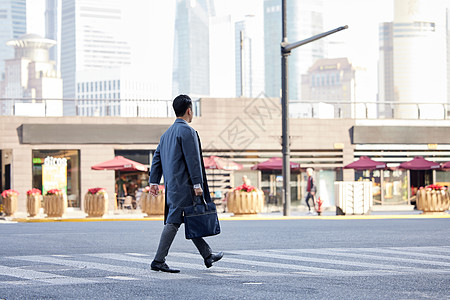 年轻男冬季都市商务白领男士过马路背影背景