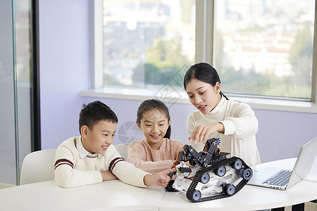机器人教室老师指导小朋友操作编程机器人背景