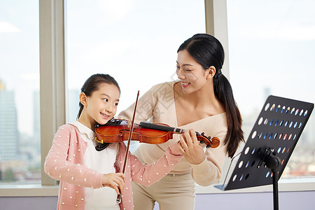 音乐老师教小女孩拉小提琴图片
