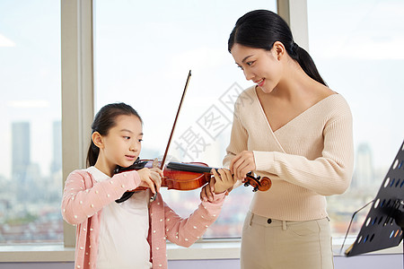老师教小女孩弹奏小提琴图片