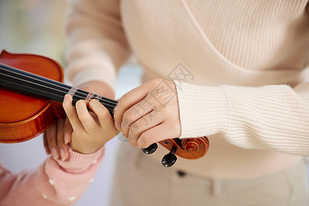 小提琴老师教小朋友琴弦特写图片