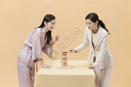 儿童玩具叠叠乐商务女性和居家女性玩桌游背景