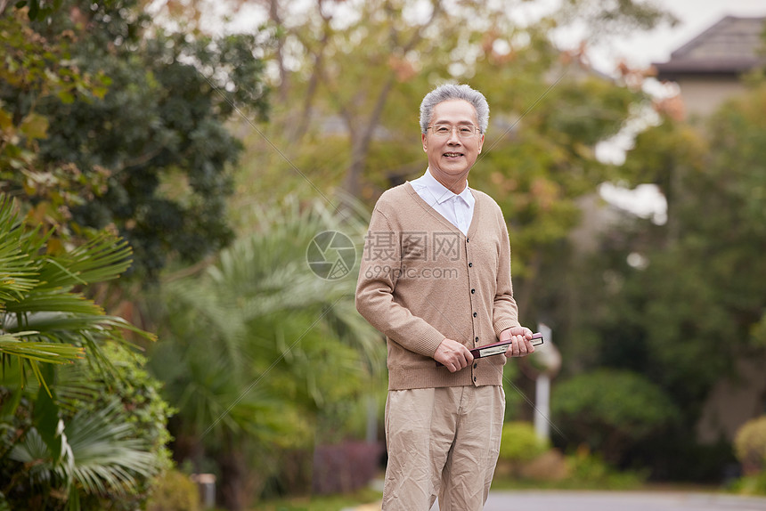 老年人小区散步欣赏花草图片