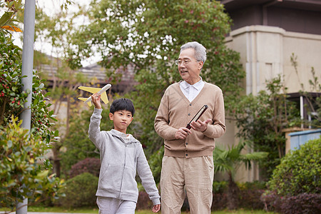 爷爷陪孙子外出散步玩耍高清图片