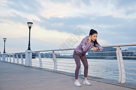 美女在江边做跑步前的热身图片