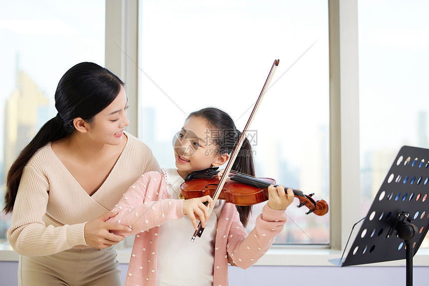 女老师指导小女孩拉小提琴图片