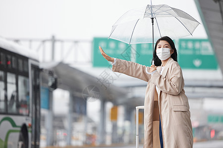 商务雨伞戴口罩户外打车的女性背景