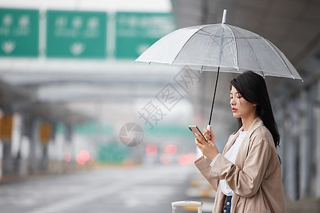 下雨雨伞在机场外撑伞等车的女性背景