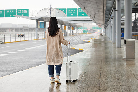 商务雨伞在机场室外撑伞等车的女性背影背景