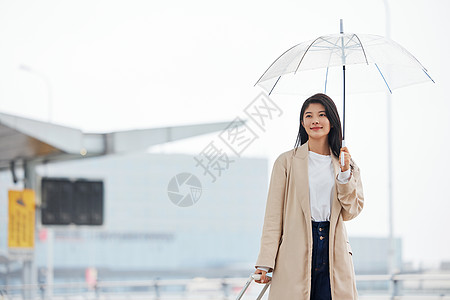 商务雨伞撑伞走在室外的女性背景