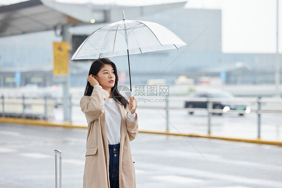 下雨撑伞等车的女性图片