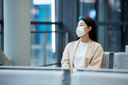 在候机厅戴口罩等待的女性图片