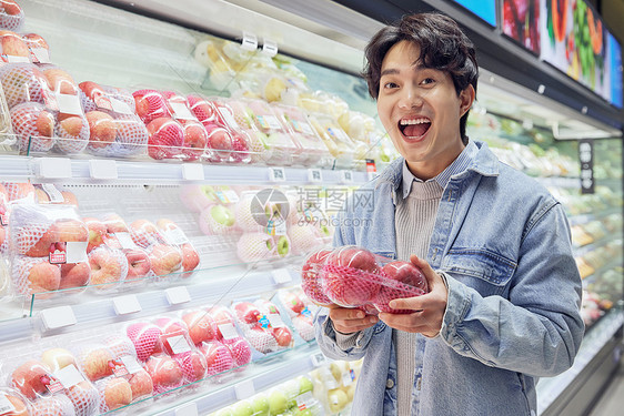 青年男性逛生鲜超市挑选水果图片