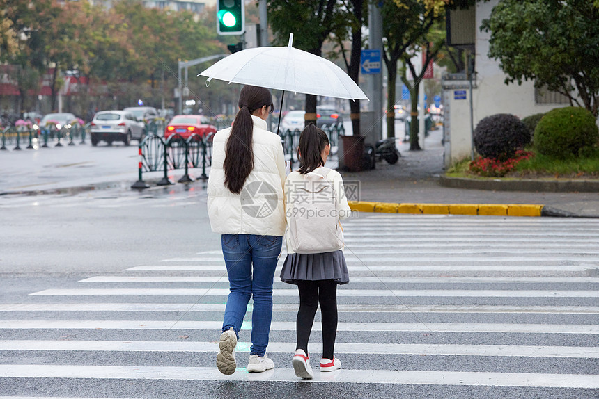 下雨天母女撑伞牵手过人行道图片