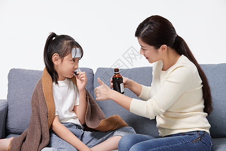 妈妈照顾生病发烧女儿吃药图片