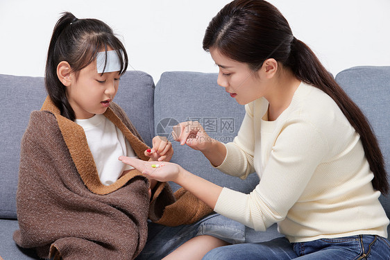 妈妈照顾生病发烧女儿吃药图片