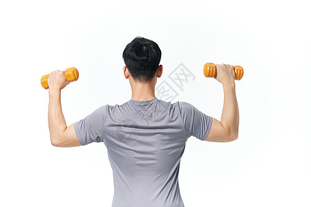 使用哑铃锻炼身体的男性背影高清图片