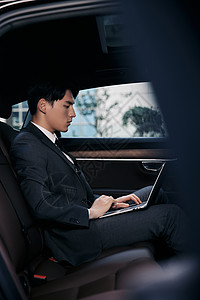 生气的老板年轻商务白领坐在轿车里用笔记本电脑办公背景