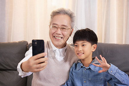 家人陪伴祖孙居家使用手机视频通话背景