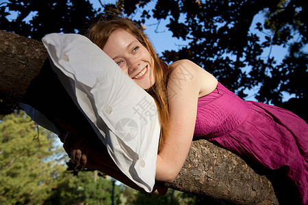趴在树上枕枕头的女孩图片