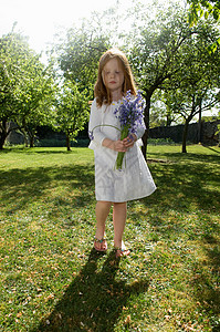 女孩在后院拿着鲜花高清图片