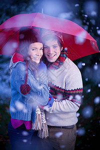雪中雨伞下微笑的情侣图片
