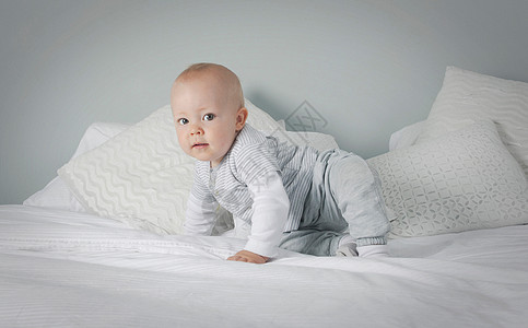 婴儿男孩在床上爬行图片