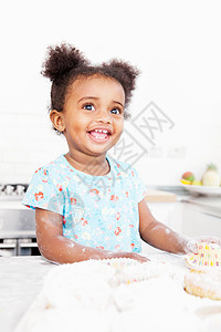 微笑的女孩在厨房烘烤图片