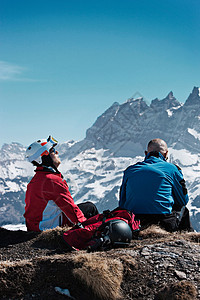 坐在岩石山顶上的滑雪者图片