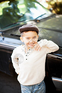 微笑的男孩靠在车边多民族高清图片素材
